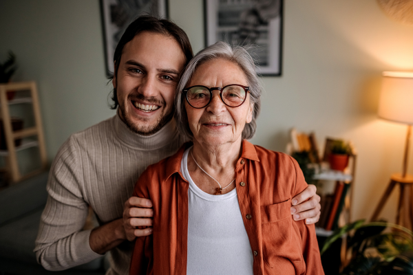 Young man and older lady standing together