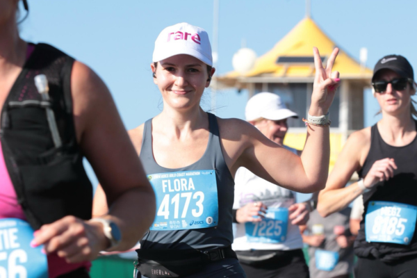 Young woman in Rare cap running in a marathon event