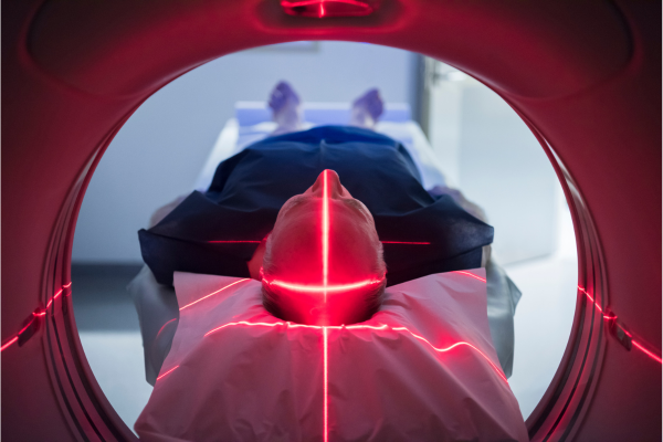 A man laying on a hospital bed receiving treatment.