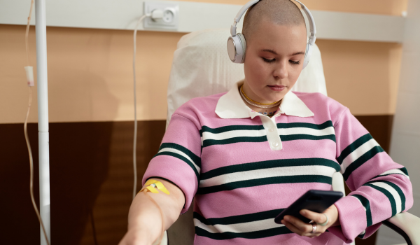 Woman in chair having cancer treatment while listening to music