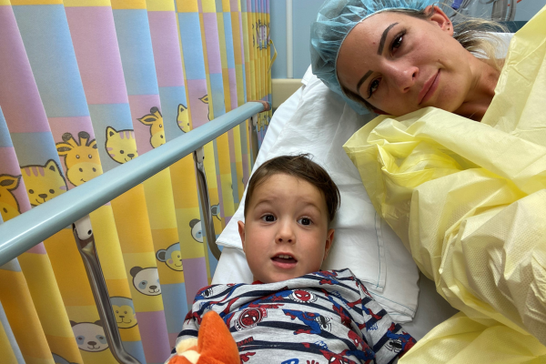 A mother and her son lieing in a hospital bed together at the childrens hospital.