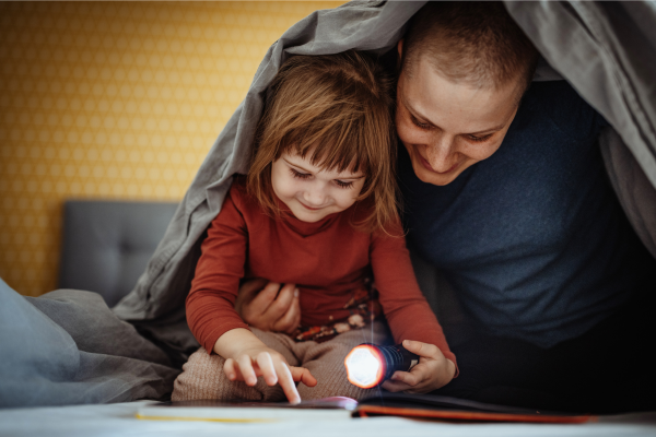 A mother is reading a book with her young daughter.