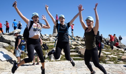 People jumping in elation at the summit of Mount Kosi.