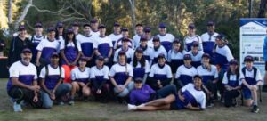 A large group of people dressed in uniform smiling for the camera