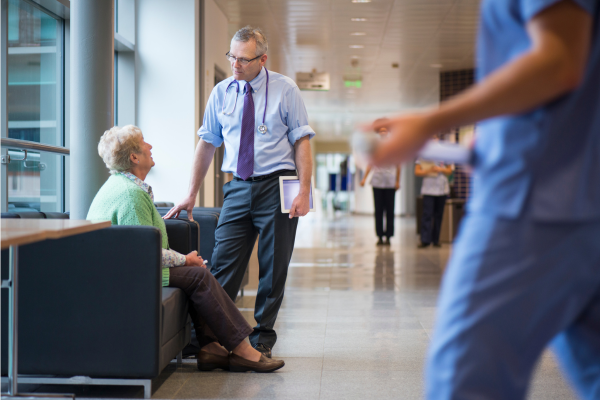 A doctor talking with his patient in a waiting room.