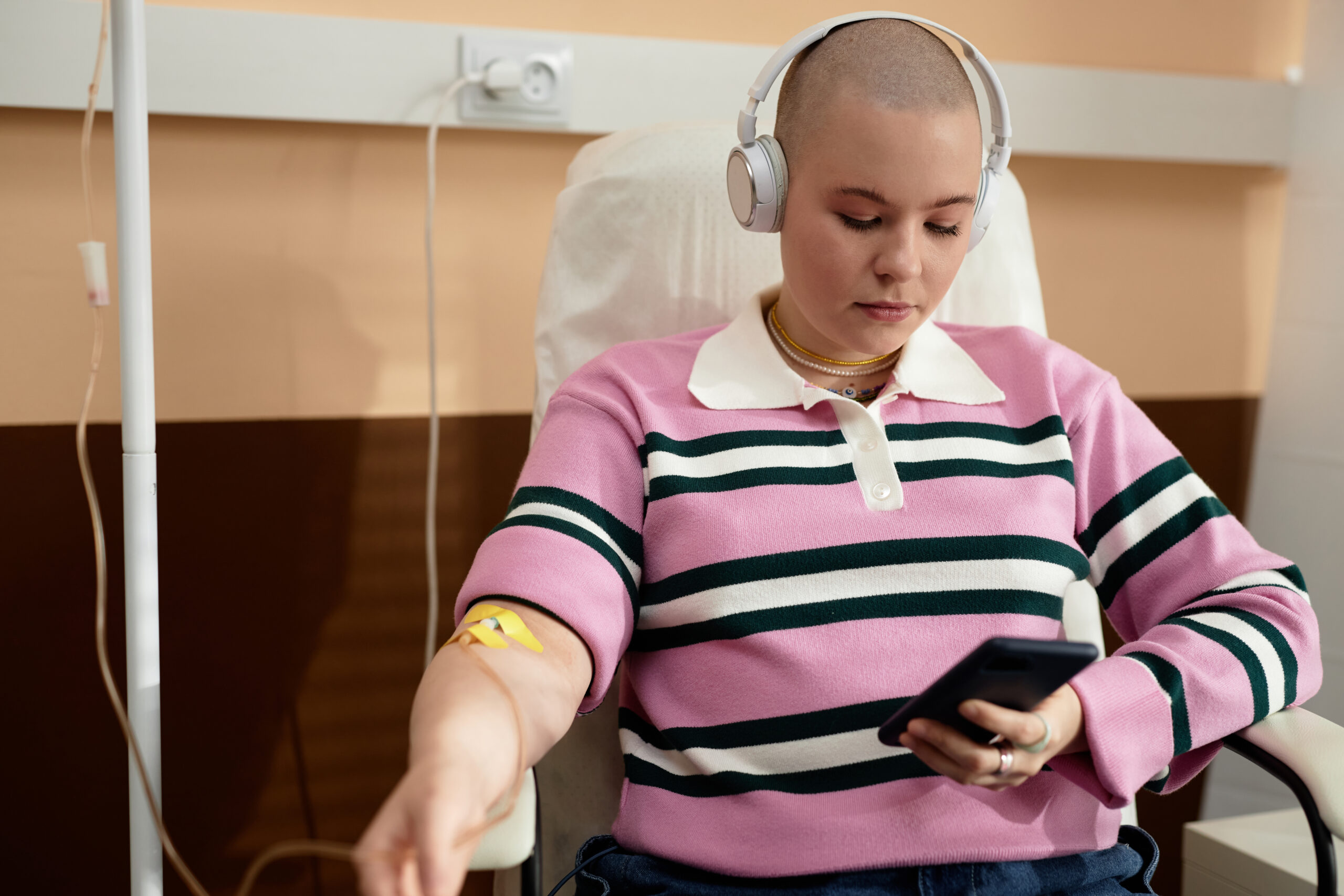 Woman in chair having cancer treatment while listening to music